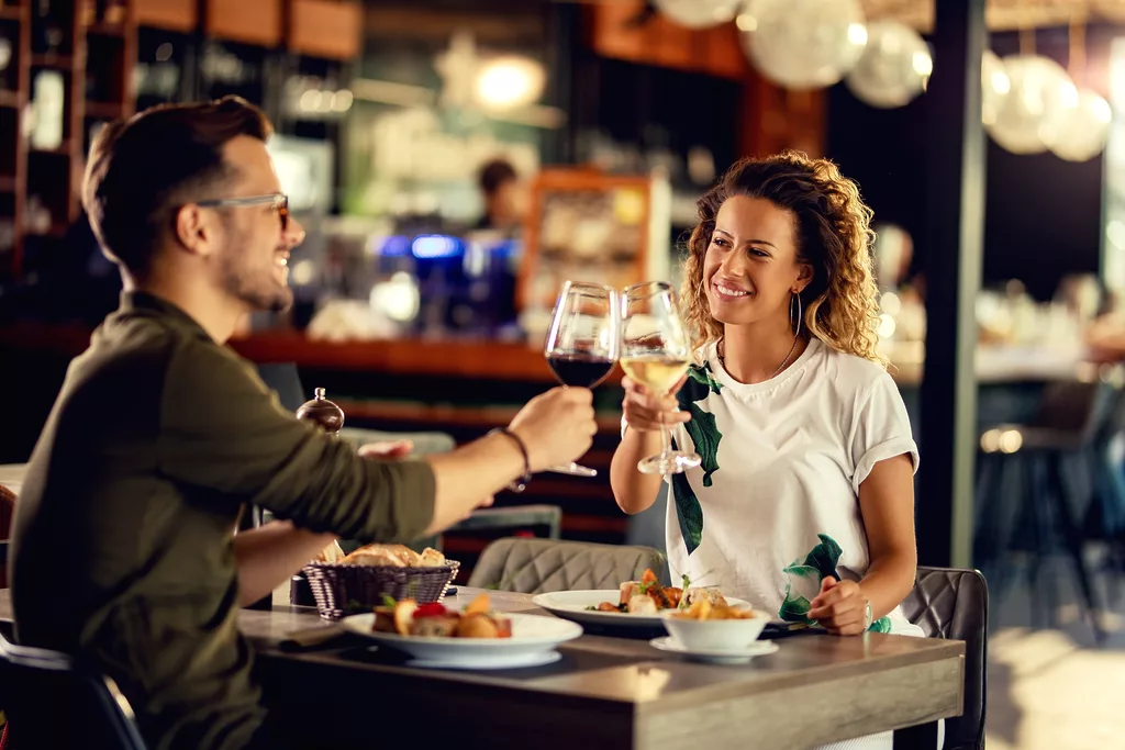 Happy Couple Toasting With Wine During Lunch In A Restaurant.